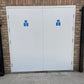 White fire door with blue signs on a brick wall