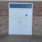 White fire rated door with a blue sign on a brick wall