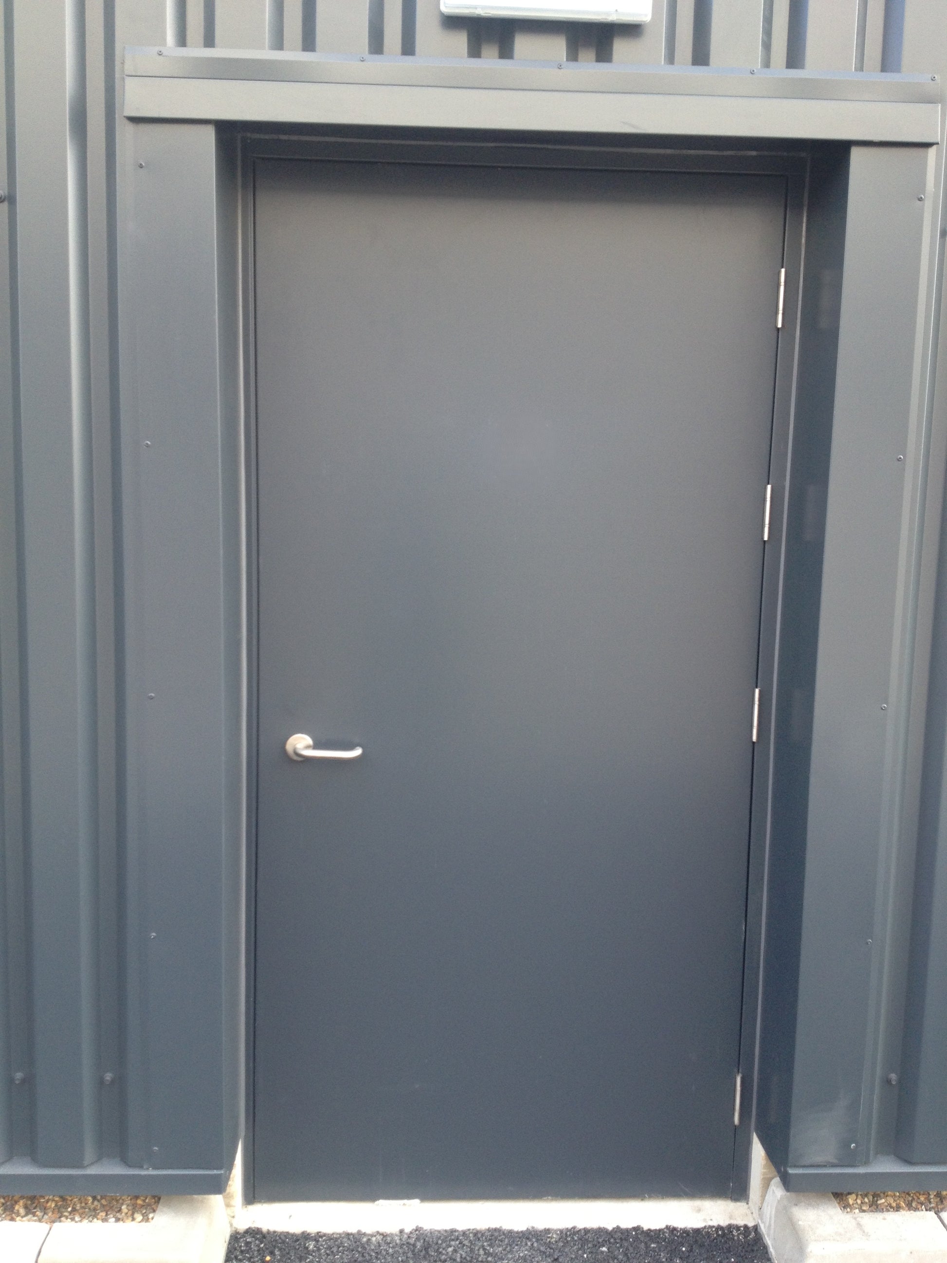 Gray metal fire rated door on a storage unit with a visible handle.